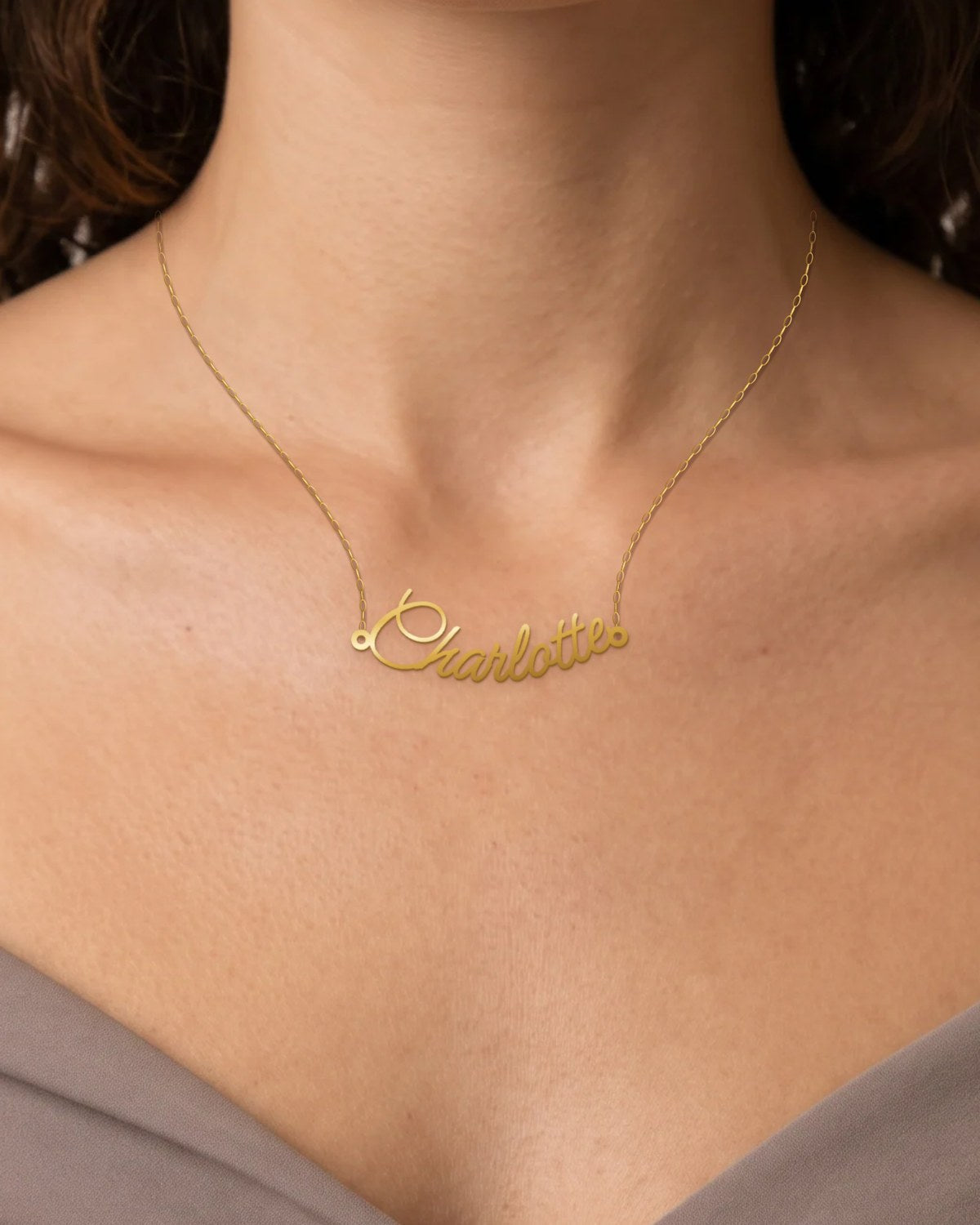 A gold name necklace reading Charlotte, worn on a 45 cm chain